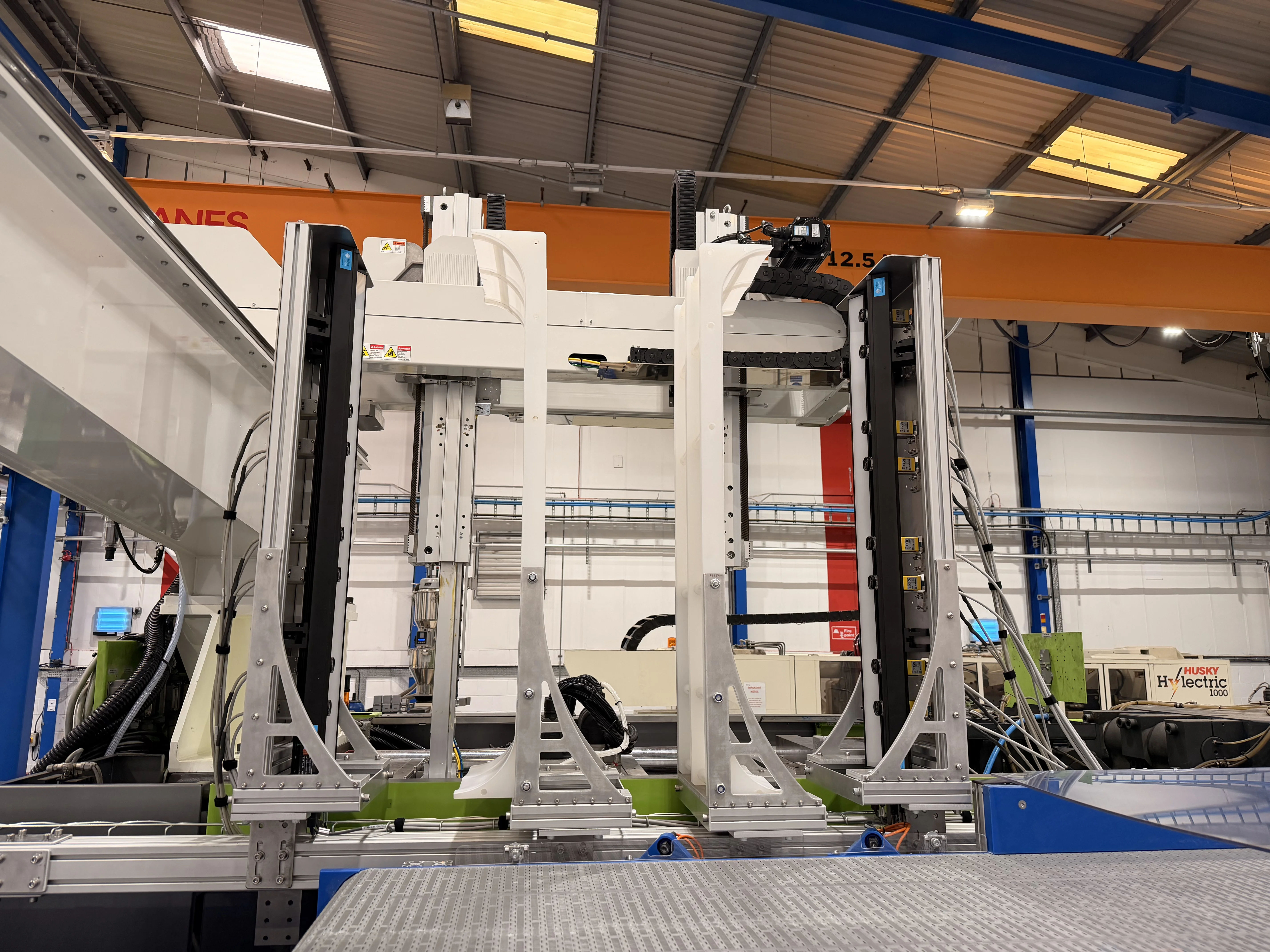 Demoulder gripper carrying sixteen-cavity moulded parts past the GenVis inspection cameras